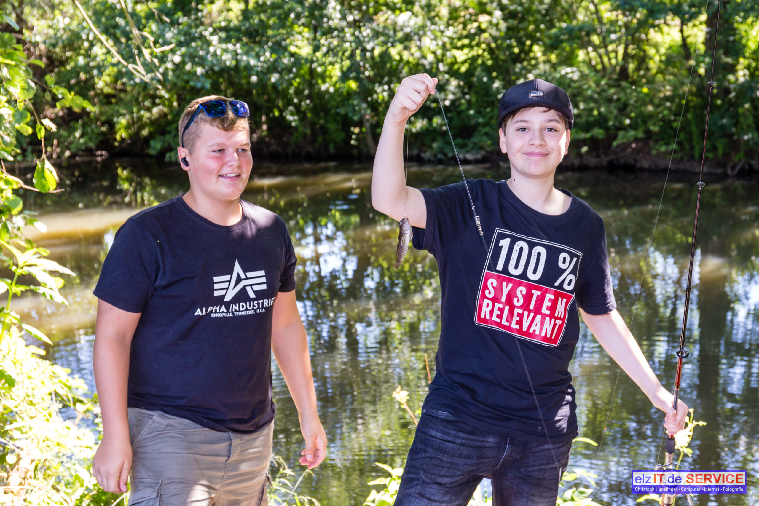 Zwei Jugendliche jubeln beim Elbbachangeln 2022 am Wasser